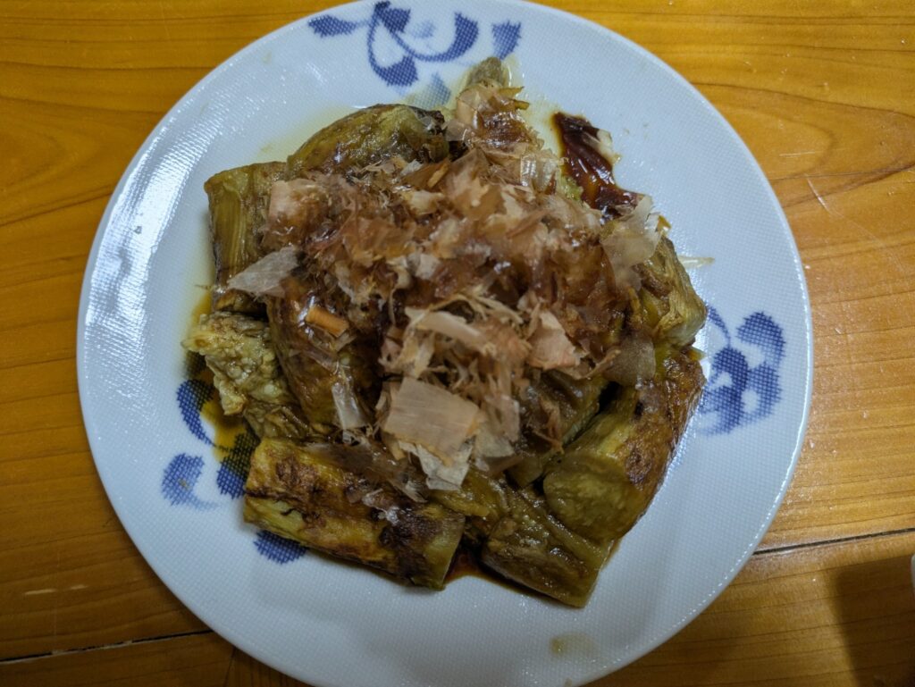 家庭菜園で収穫したナスを焼き、かつお節をのせて皿に盛り付けた焼きナス